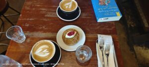 فناجين لاتيه وحلوى على طاولة في مقهى VCR – كوالالمبور – تصوير فيصل علي